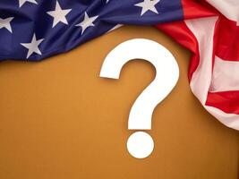 White question mark over a brown background with the American flag on top photo