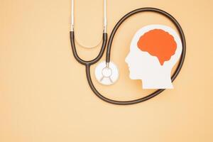 A brain shape made from paper and a stethoscope on a light orange background photo