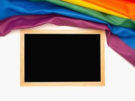 Top view of the rainbow flag or LGBT and a blank mini chalkboard with the wooden border over a white background photo