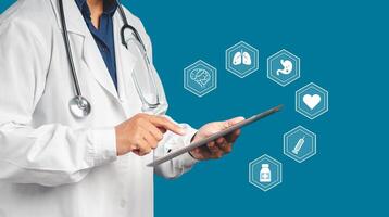 A doctor in uniform holding a tablet with health icons while standing on a blue background photo