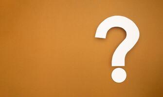A question mark symbol is on a brown background photo