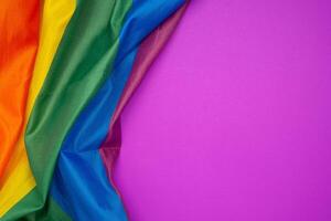The rainbow flag or LGBT is on a purple background with copy space for text photo