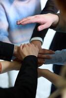A top view of business people joining hands in a circle, symbolizing unity, collaboration, and shared success in the workplace photo