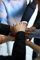 A top view of business people joining hands in a circle, symbolizing unity, collaboration, and shared success in the workplace photo