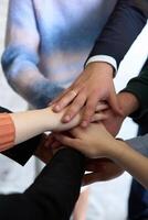 A top view of business people joining hands in a circle, symbolizing unity, collaboration, and shared success in the workplace photo