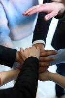 A top view of business people joining hands in a circle, symbolizing unity, collaboration, and shared success in the workplace photo