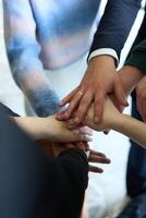 A top view of business people joining hands in a circle, symbolizing unity, collaboration, and shared success in the workplace photo