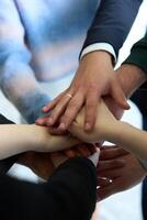 A top view of business people joining hands in a circle, symbolizing unity, collaboration, and shared success in the workplace photo