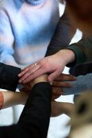 A top view of business people joining hands in a circle, symbolizing unity, collaboration, and shared success in the workplace photo