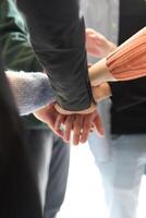 A top view of business people joining hands in a circle, symbolizing unity, collaboration, and shared success in the workplace photo