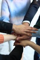 A top view of business people joining hands in a circle, symbolizing unity, collaboration, and shared success in the workplace photo