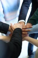 A top view of business people joining hands in a circle, symbolizing unity, collaboration, and shared success in the workplace photo