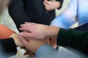 A top view of business people joining hands in a circle, symbolizing unity, collaboration, and shared success in the workplace photo