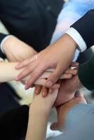 A top view of business people joining hands in a circle, symbolizing unity, collaboration, and shared success in the workplace photo