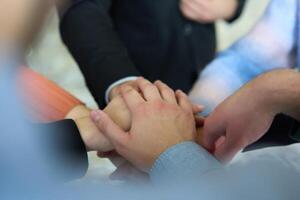 A top view of business people joining hands in a circle, symbolizing unity, collaboration, and shared success in the workplace photo