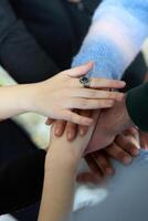 A top view of business people joining hands in a circle, symbolizing unity, collaboration, and shared success in the workplace photo
