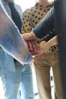 A top view of business people joining hands in a circle, symbolizing unity, collaboration, and shared success in the workplace photo
