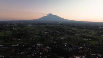 Panoramic aerial drone footage of Mount Merapi from a distance with beautiful views in the morning. 4k landscape of active volcano in detail with green forest in front. video