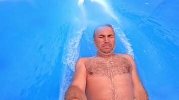 Man having fun on a water slide in a water park video