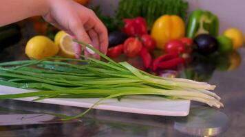 Bunch of green onion feathers with drops of water on a cutting board, Close-up macro rotating shot. video