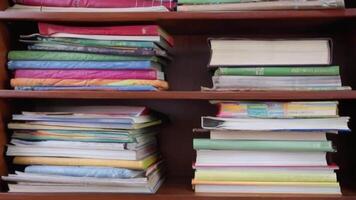 un estante para libros organizado por color, con un soltero libro siendo tirado fuera despacio video