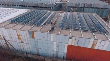 Solar panels on the roof. Engineers installing photovoltaic solar batteries. Alternative energy. Buildings with many sunny cells on roofs. Aerial view. video