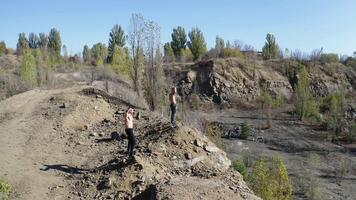 Sporty men with muscular body on the rocky hills. Two athletic guys without shirt having workout on the beautiful nature background in summer. Aerial view. video