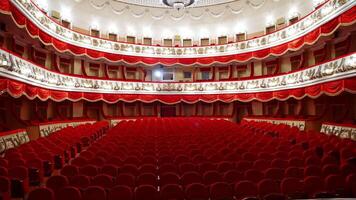 Kyiv, Ukraine, 29 May 2024 Selective focus on empty rows with red velvet seats in theater hall. Rows with empty chairs. No people because of covid-19. video