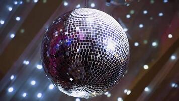 Round mirror ball shimmering. Shining disco ball hanging on the ceiling and rotating at nightclub. Close-up. video