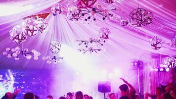 Beautiful ceiling with colored lights at nightclub. Different sized looped stage lamps on the ceiling and lasers canons shimmering over people in the disco hall. video