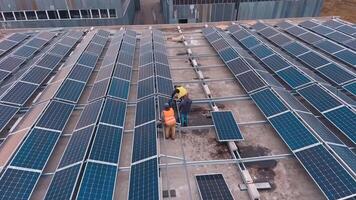 Installing solar panels on the foof of plant or factory. Additional source of electricity. Green energy. from the top. video