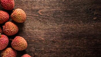 top-down view of fresh lychee fruits with vibrant pink and red skin, arranged on a rustic wooden background, showcasing textured surface and natural tropical fruit aesthetic photo