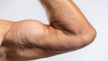 close-up macro of wrinkled and textured human elbow showing skin folds and dryness details on isolated white background photo