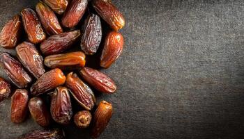 top-down view of glossy dried dates piled on rustic burlap fabric with empty right-side space for text or design elements photo