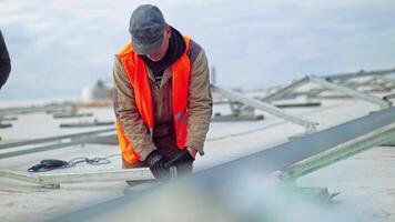 Technicians building metal base for solar panels. Metal basis installation. Workers construct new solar farm on a roof. video