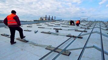 Workers install metal base for solar panels. Construction of new solar farm under the motion of clouds in the sky. Time lapse. video