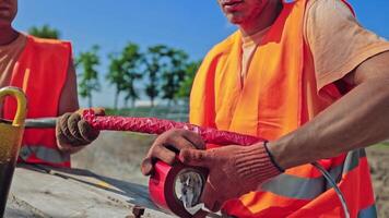 Engineers on the solar farm construction. Workers build new ecological power station on the field. Men technician working with pipes for clean energy. video