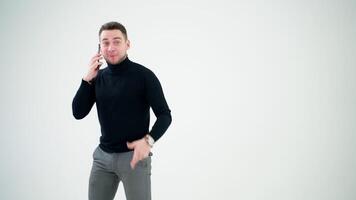 feliz jovem homem falando em Móvel telefone. homem de negocios com uma telefone isolado sobre luz fundo. social distanciar e auto isolamento dentro quarentena confinamento. video