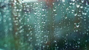 Glass window in rainy weather with raindrops. Falling drops. Wet window with drops and white dots. Close-up. video