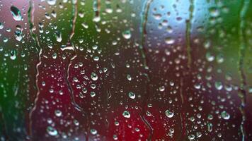 Rainy background on glass. Raindrops on window on blur background of bright dots. Drops of rain flow down the window. Drops of water drops on window pane. video
