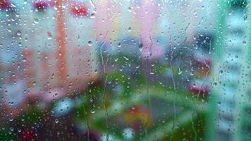 Window at rainy day on blur city background. Wet raindrops on window glass. Abstract raindrop scenery background. video