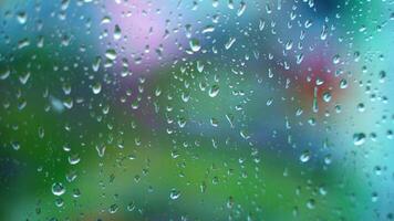 Glass background with raindrops. Water drops flowing on window surface with blur moving dots outside. Close-up. video