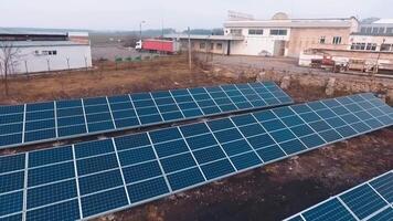 azul solar painéis em fábrica fundo às pôr do sol. Inovativa fonte do obtendo ecológico energia a partir de a Sol. movimento Câmera voltar. video
