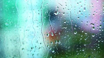 Wet window with raindrops. Water drops moving down on glass window on blur view background. Close-up. video