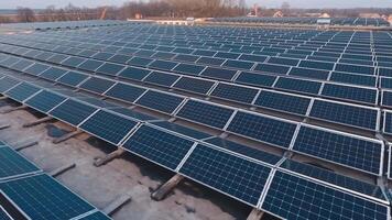 linhas do fotovoltaico painéis em uma plano teto. enorme território em a topo do a construção com solar painéis. alternativo fonte do limpar \ limpo energia a partir de a Sol. aéreo visualizar. video
