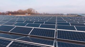Sustainable source of energy. Modern photovoltaic cells on a flat roof. Innovative solar panels generate ecological energy from the sun. Aerial view. Motion camera back. video