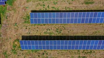 Photovoltaic solar panels on the ground. Blue sunny batteries generate clean energy into electricity. Alternative energy. View from above. Slow motion. video