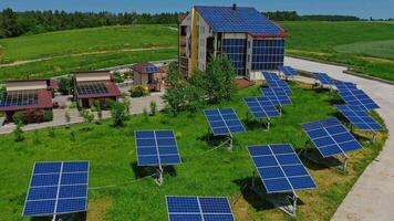 Solar panels on grass. Modern building among nature with innovative blue solar cells in roof and side wall. Alternative green energy production. Aerial view. video