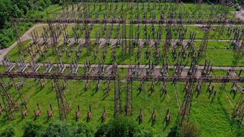 Electric supports among green field.Flight over huge field with high voltage steel pylons. High voltage lines in nature. Aerial view. video