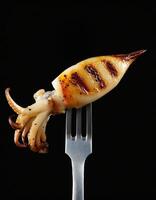 grilled squid with golden char marks on a sleek two-prong fork ideal for seafood menus and gourmet food photography photo